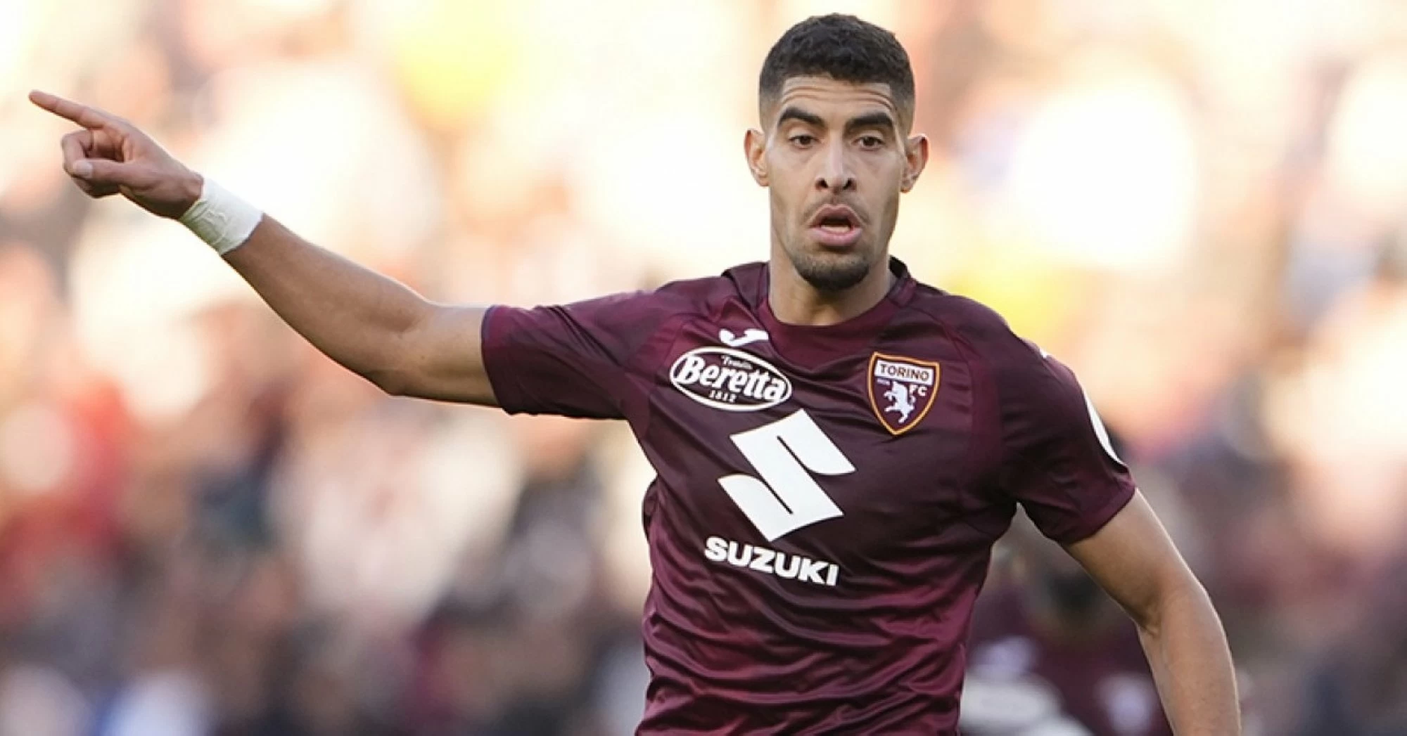 آدم ماسينا المنتخب المغربي بقميص نادي تورينو الإيطالي وهو ينظر بتفكير على أرض الملعب.