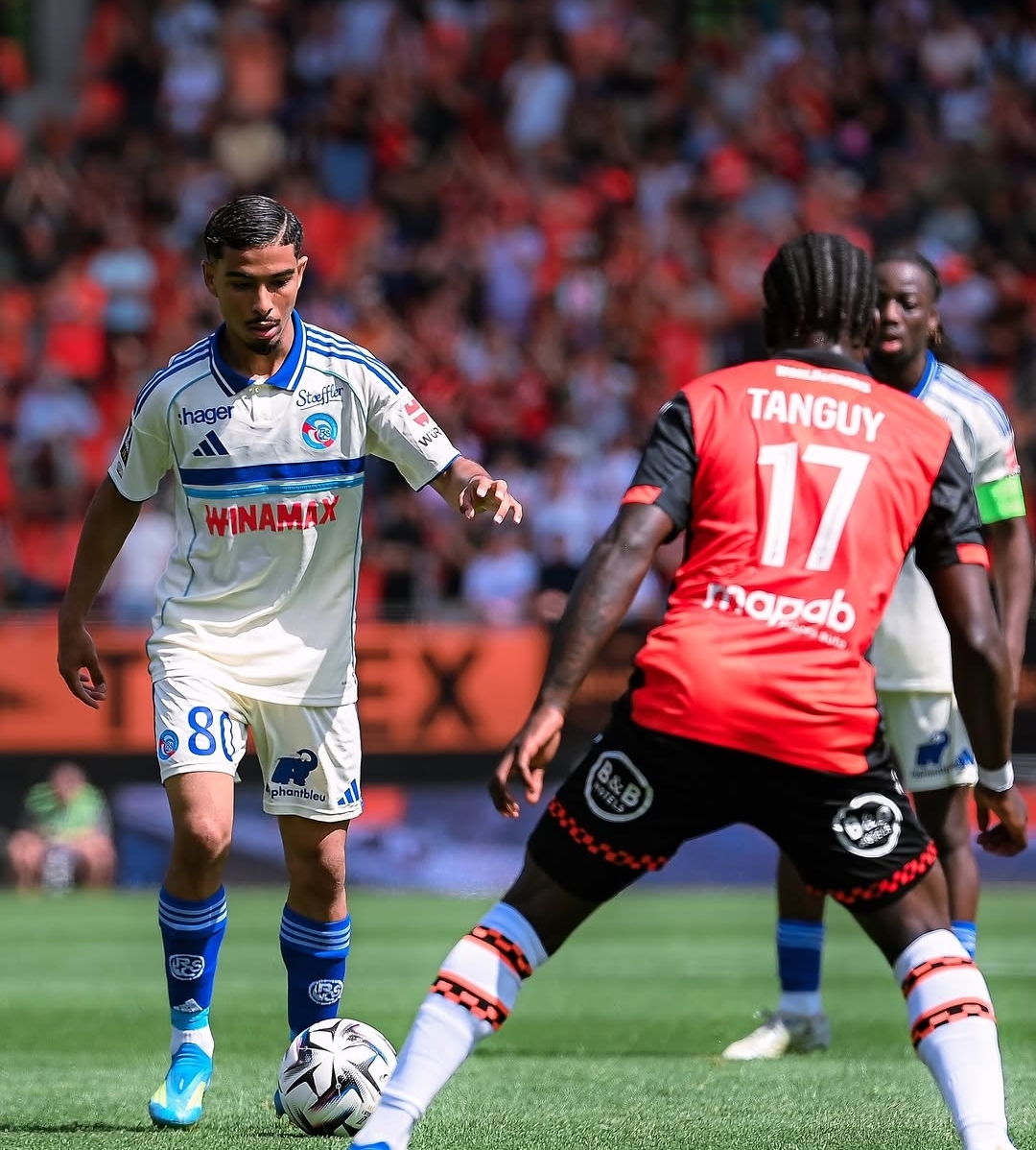 لاعب كرة قدم يرتدي قميصًا أبيض يحمل الرقم 8 ويتحكم في الكرة داخل الملعب.