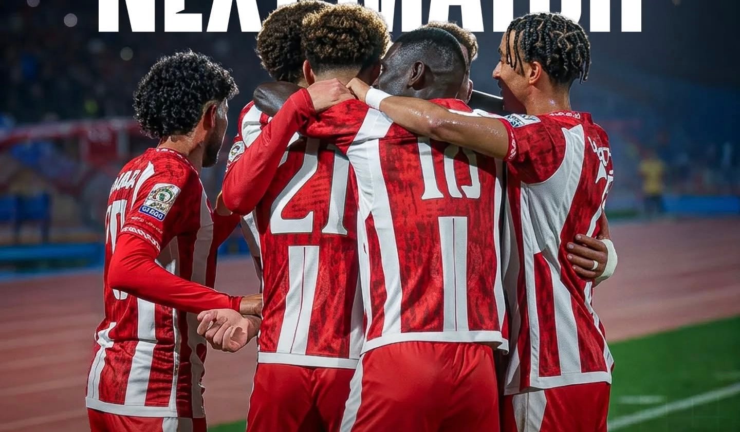 لاعبان يتنافسان على الكرة في مباراة كرة قدم بحضور الجمهور