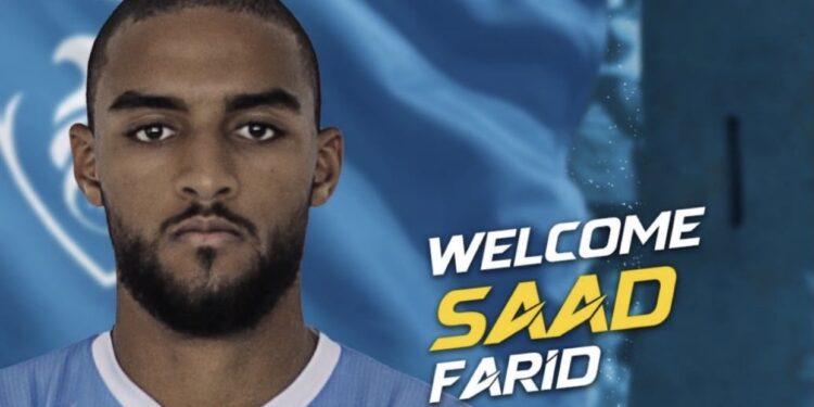 حتا الإماراتي يضم رسمياً سعد فريد من الرجاء الرياضي 1 اللاعب سعد فريد ينظر إلى الكاميرا بخلفية زرقاء وصفراء، يظهر فيها بملامح جادة.