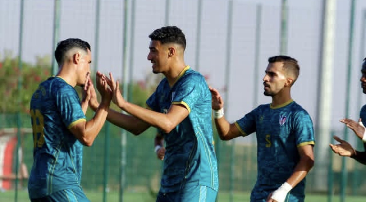 لاعب من المغرب التطواني يصفق بجانب لاعب آخر.